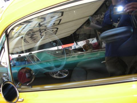 1998 Ford Crown Victoria - Looking through a side window into a teal classic car interior, with the photographer's reflection and flash visible in the glass.