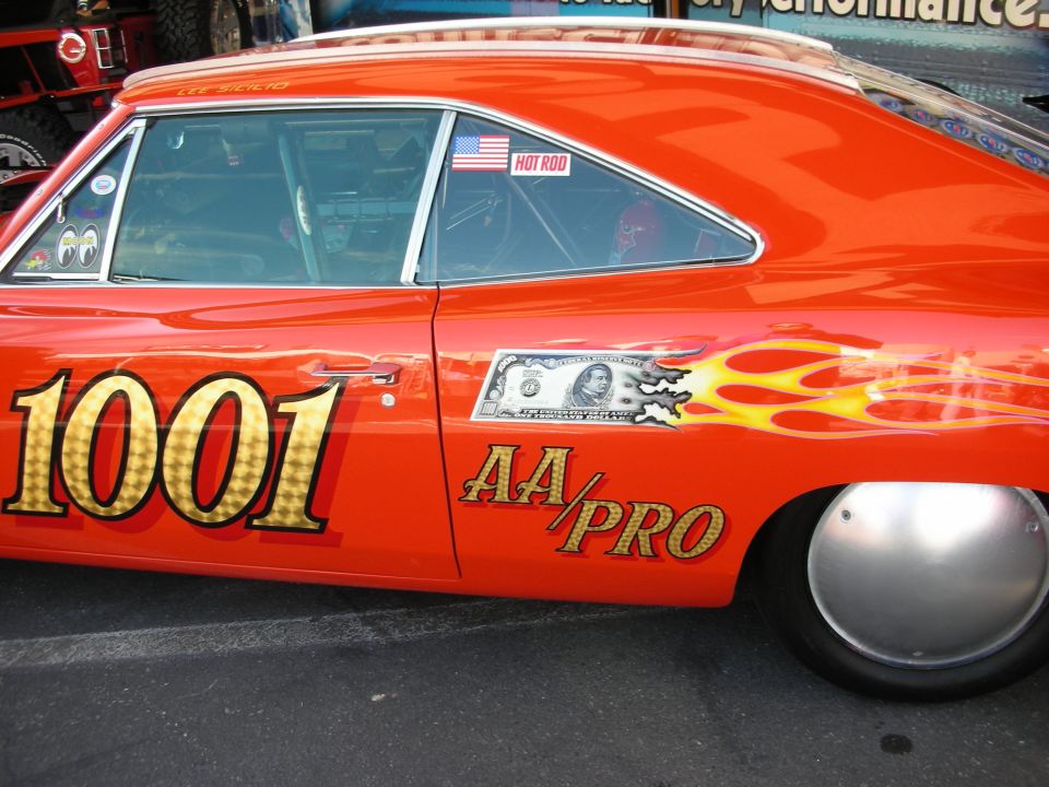 Side of orange drag car with flames, number 1001 and AA/PRO lettering