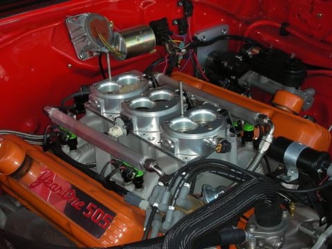 1998 Ford Crown Victoria - orange engine fitted with individual-throttle stack injection sits in a red engine bay, valve covers labeled Year One 505.