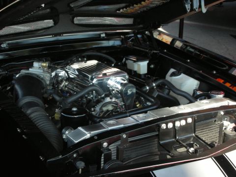 1998 Ford Crown Victoria - open engine bay reveals a supercharged V8 with a chrome blower, polished accessories and a white coolant reservoir.