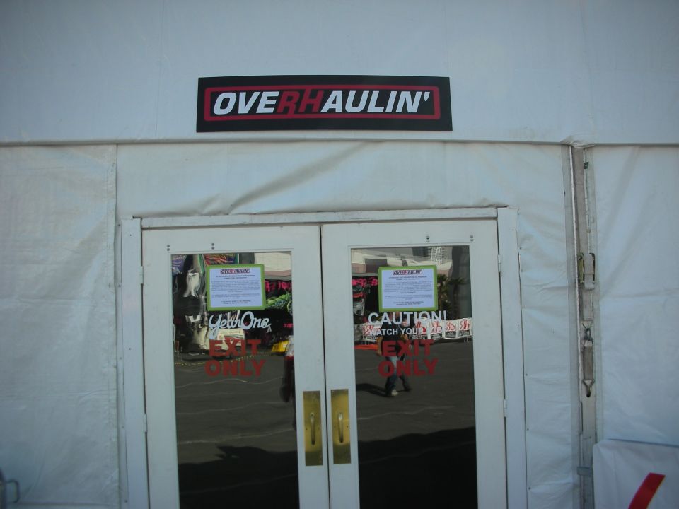 White tent entrance with Overhaulin' sign above glass double doors