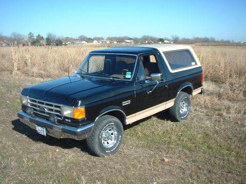 1988 Ford Bronco - This 1988 Ford Bronco is captured in a three-quarter front view, its black exterior and tan removable top.