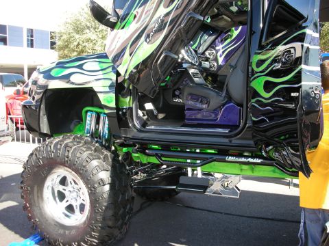 1998 Ford Crown Victoria - lowered side view of a lifted custom truck with green flame graphics and a custom interior.