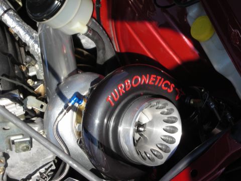 1998 Ford Crown Victoria - large polished Turbonetics turbocharger mounted in a red engine bay.