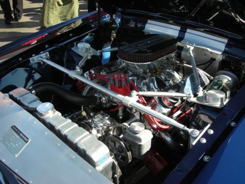 1998 Ford Crown Victoria - built V8 with chrome air cleaner, red plug wires and strut brace in a blue muscle-car bay.
