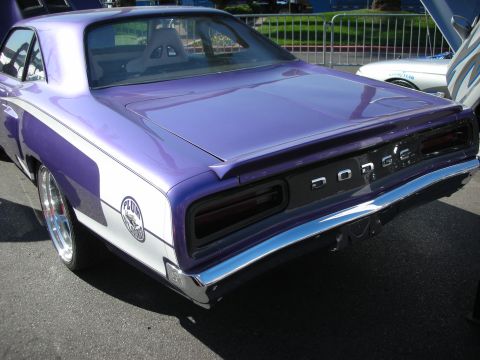 1998 Ford Crown Victoria - Rear of a purple-and-white classic Dodge muscle car with chrome wheels and a DODGE tail panel.