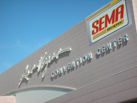 1998 Ford Crown Victoria - Las Vegas Convention Center facade displaying a SEMA Show banner against a clear sky.