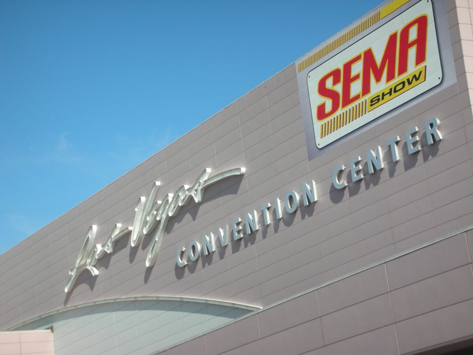 Las Vegas Convention Center facade with a SEMA Show banner against blue sky
