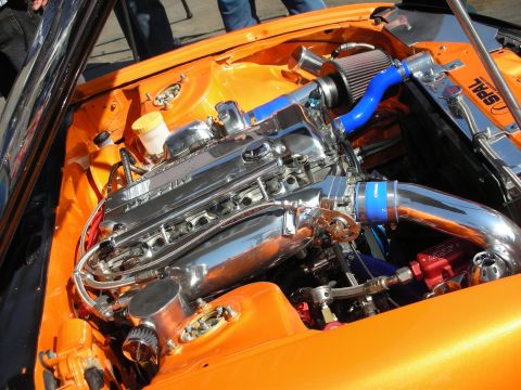 1998 Ford Crown Victoria - polished inline engine with blue intake piping and SPAL fans sits in an orange engine bay.