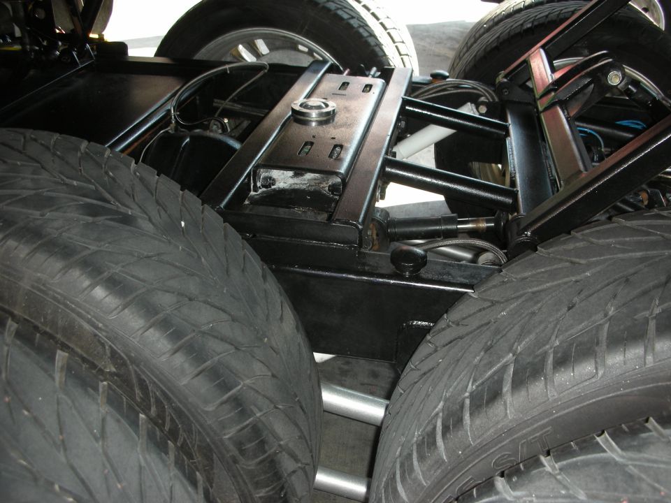 Underside chassis view showing dual rear tires and black suspension frame