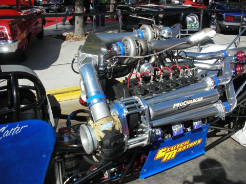 1998 Ford Crown Victoria - polished ProCharger-supercharged dragster engine mounted on a blue rail chassis with a Clutch Masters panel at a car show.
