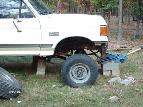 1990 Ford F-150 - White Ford F-250 front end is raised on jack stands with the front tire removed. The photo is dated 11/13/2006.