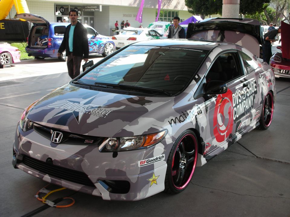 Honda Civic coupe with gray camouflage wrap and pink-lipped wheels