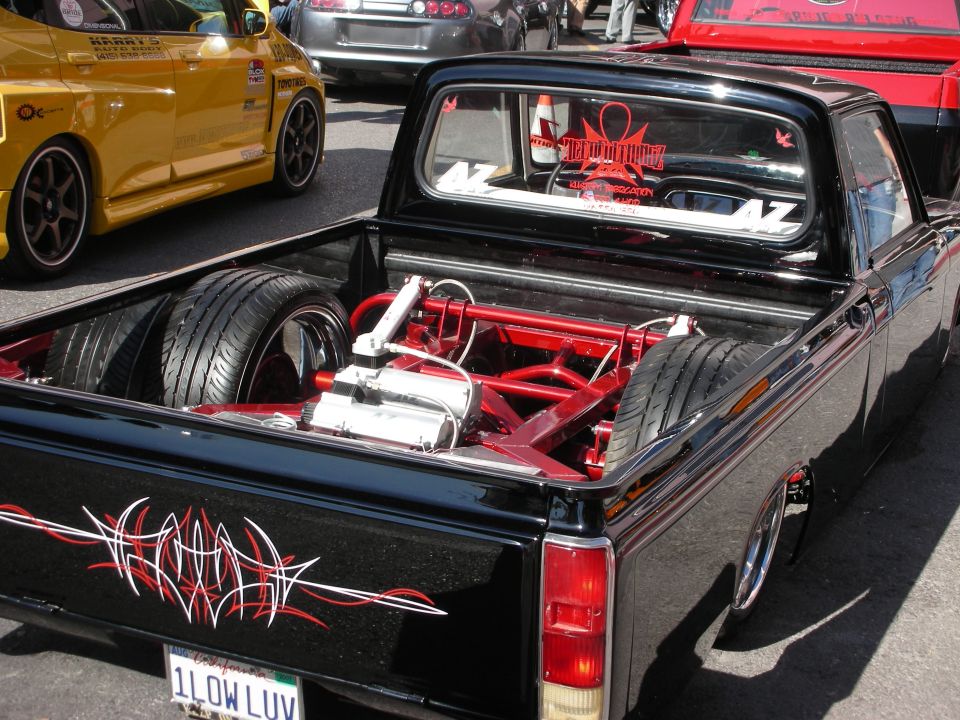 Lowered black mini pickup with red bed engine swap and 1LOWLUV plate