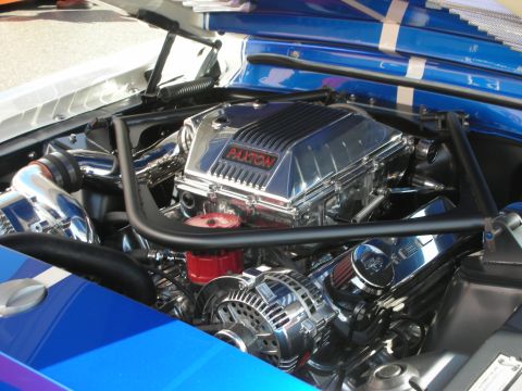 1998 Ford Crown Victoria - Engine bay of a blue car showing a chrome Paxton supercharger over a polished V8 with a roll bar overhead.