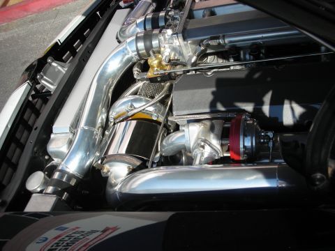 1998 Ford Crown Victoria - Polished intake piping, a carbon filter and a red blow-off valve fill a brightly chromed custom engine bay.