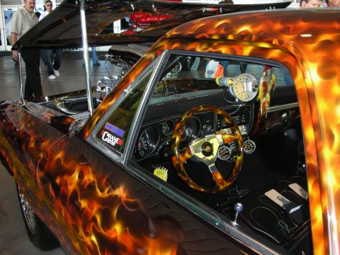 1998 Ford Crown Victoria - custom car features vivid airbrushed flames over the body and a matching flame-pattern steering wheel inside.