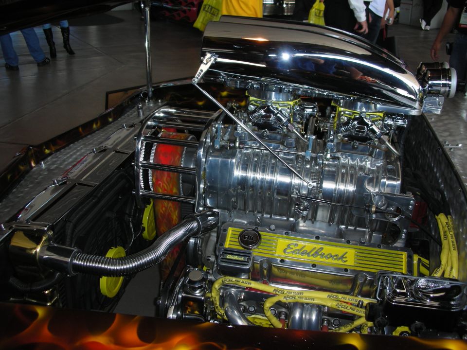 Chrome supercharger with scoop and Edelbrock valve covers in a flame-painted engine bay