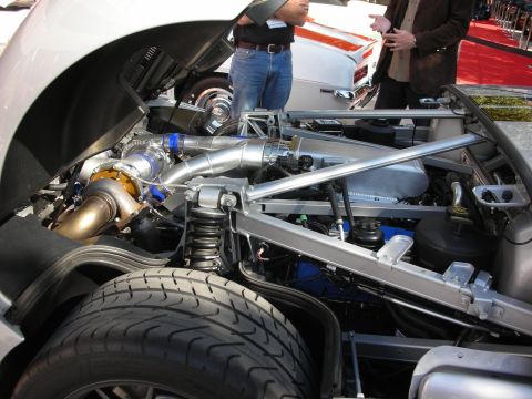 1998 Ford Crown Victoria - mid-mounted engine of a silver Ford GT shows a gold turbocharger, polished piping and tube-framed suspension.