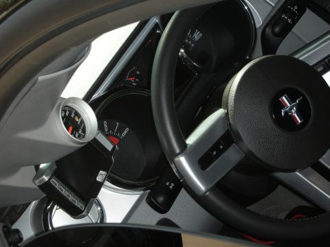 1998 Ford Crown Victoria - Interior view of a Mustang showing the pony-badged steering wheel, gauge cluster and an extra mounted gauge.