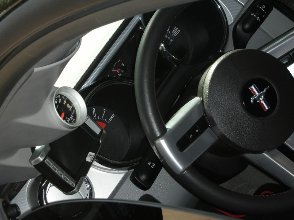 Mustang interior showing steering wheel with pony badge and gauge cluster