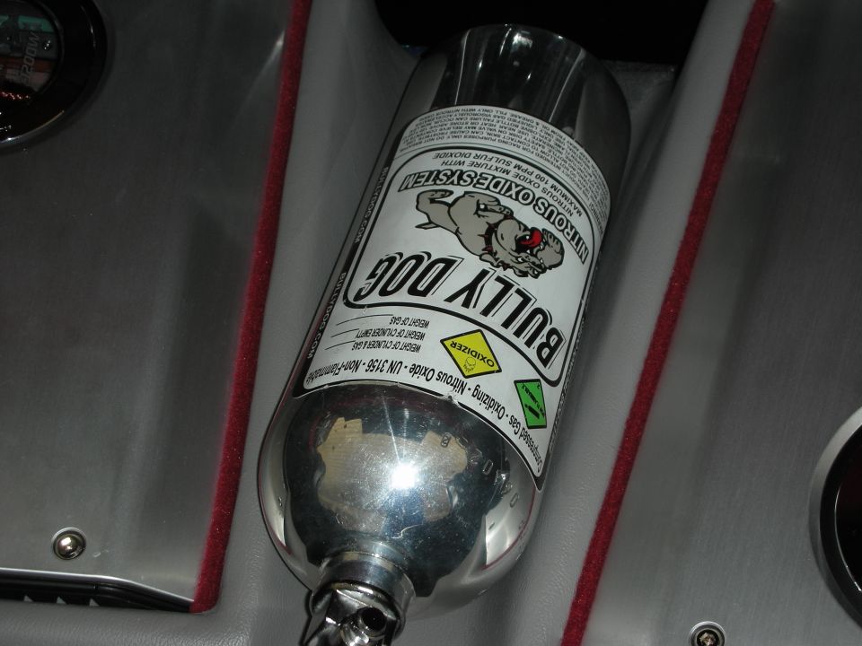 Polished Bully Dog nitrous oxide bottle mounted in a carpeted car trunk