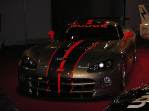 1998 Ford Crown Victoria - silver Dodge Viper with red and black racing stripes and 'Dodge' windshield banner shown in a dimly lit display.