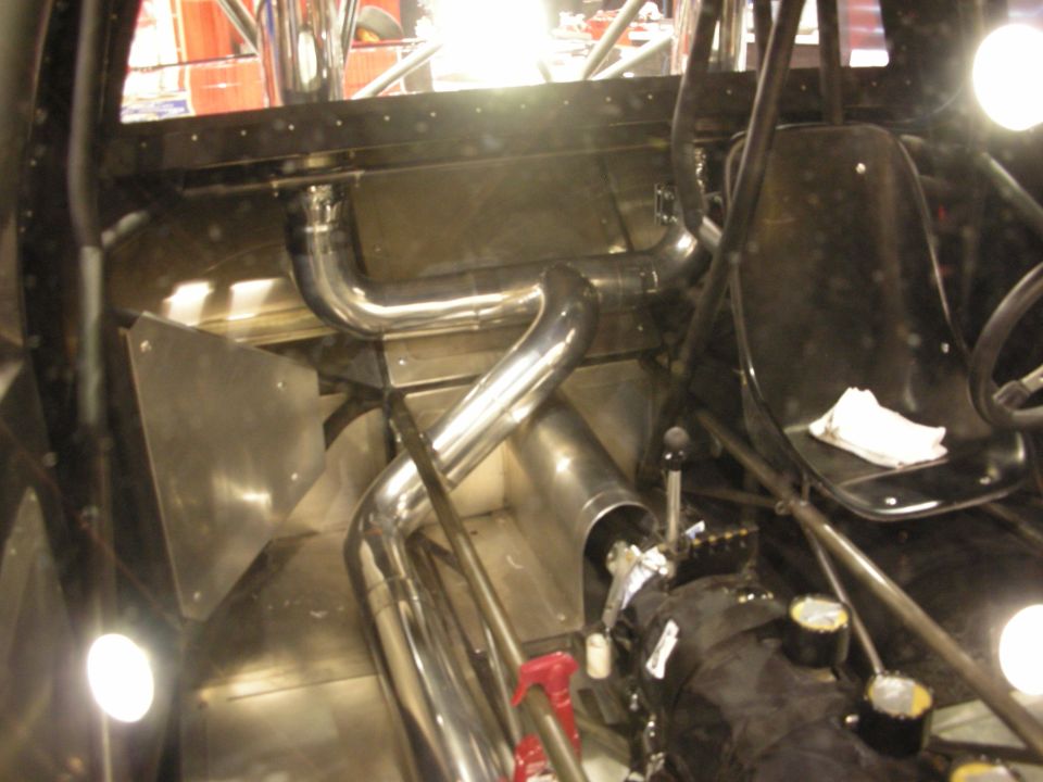 Tubular roll-cage interior of a tube-chassis race car with stainless exhaust