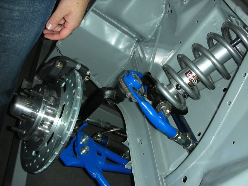 Front suspension closeup with drilled brake rotor, coilover and blue control arm