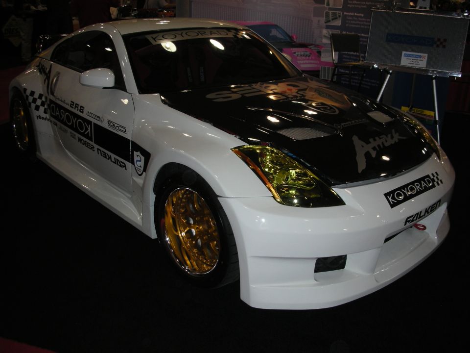 Front-quarter view of white sponsored Nissan 350Z with gold wheels