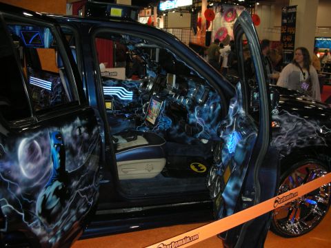 1998 Ford Crown Victoria - Open-door view of a custom truck with Batman airbrushed graphics, blue lightning theme, multiple video screens and audio system.
