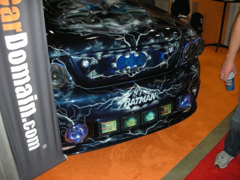 1998 Ford Crown Victoria - Front end of a custom car airbrushed with a Batman logo, lightning bolts and embedded video screens beside a CarDomain banner.
