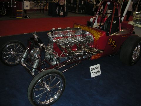 1998 Ford Crown Victoria - Red open-wheel T-bucket hot rod with a chrome multi-carb inline engine, flame paint and number 33-7 beside a Do Not Touch sign.