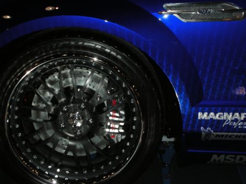 1998 Ford Crown Victoria - Close-up of a black multi-spoke wheel with a red brake caliper on a blue car carrying Magnaflow, Michelin and MSD decals.