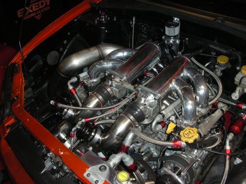 1998 Ford Crown Victoria - heavily polished tubular intake manifold and braided lines fill an engine bay near an Exedy racing clutch banner.