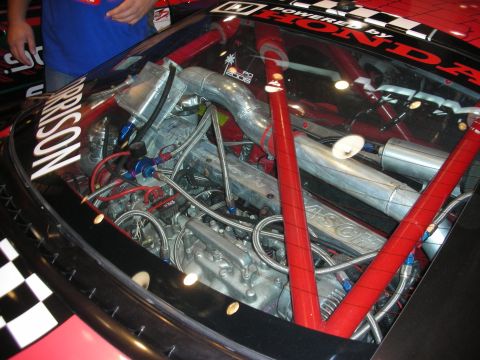 1998 Ford Crown Victoria - detailed race-car engine bay viewed through glass, marked Powered by Honda with red braces and Hasport components.