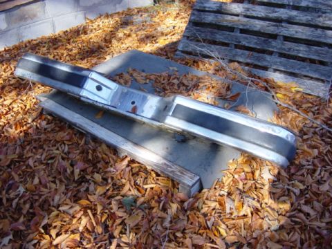 1991 Ford Bronco - A chrome and black front bumper is pictured outdoors, resting on a bed of fallen autumn leaves.