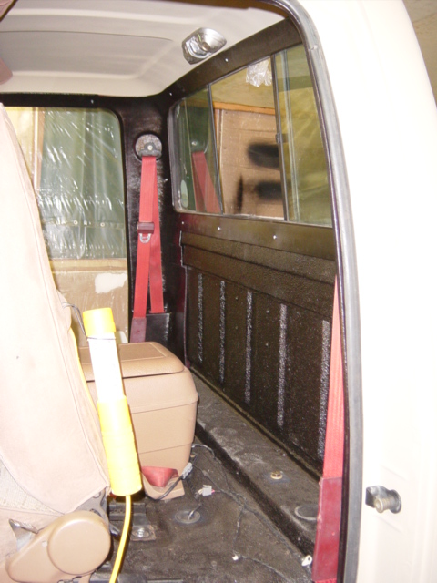 1991 Ford Bronco - The interior of the vehicle shows tan seats, red seatbelts, and a center console, with visible wear and tear.
