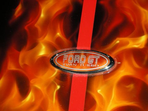 1998 Ford Crown Victoria - chrome Ford GT Twin Turbo oval badge set on a red stripe over an airbrushed orange flame paint panel.