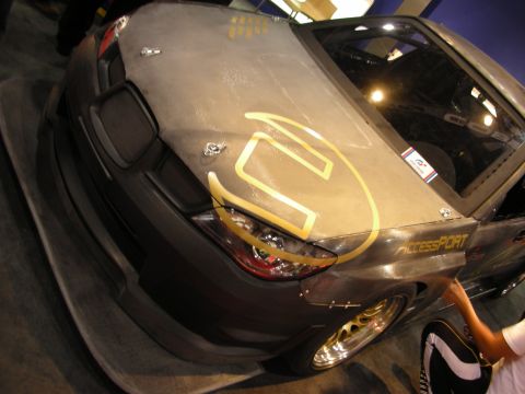 1998 Ford Crown Victoria - Front quarter of a carbon-fiber-bodied sports car with gold wheels, a gold logo on the hood and AccessPort decal.
