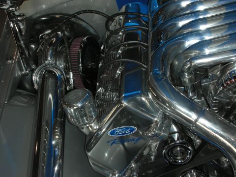 1998 Ford Crown Victoria - Close-up of a polished engine showing a chrome Ford Racing valve cover, headers and a chrome cone air filter.