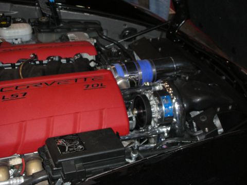 1998 Ford Crown Victoria - red-covered Corvette LS7 7.0L V8 with a polished centrifugal supercharger and blue couplers sits in a black engine bay.