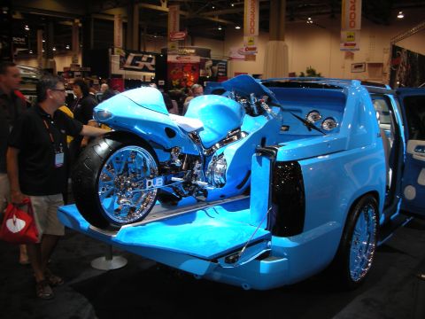 1998 Ford Crown Victoria - blue custom Cadillac Escalade EXT pickup carries a matching blue chromed sportbike on its dropped tailgate at a show.