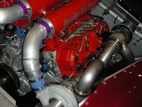 1998 Ford Crown Victoria - Close-up of a twin-turbo Banks diesel engine featuring a red block with purple-collared and stainless intercooler piping.