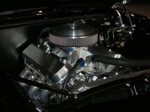 1998 Ford Crown Victoria - custom V8 engine topped with a round chrome air cleaner sits in a dark engine bay with braided lines and valve covers.