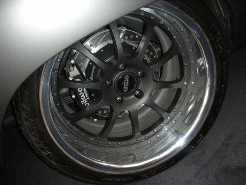 1998 Ford Crown Victoria - Close-up of a black multi-spoke alloy wheel with a polished lip, drilled rotor and red Wilwood brake caliper.