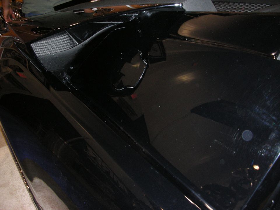 Glossy black custom car body panel with sculpted scoop, indoor