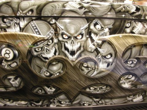 1998 Ford Crown Victoria - Detail of an airbrushed mural featuring a horned grey skull, 8-ball and faded watermark text on a glossy vehicle surface.