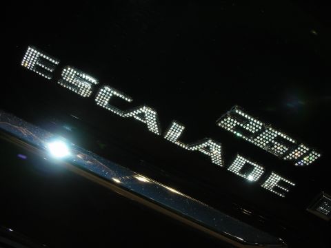 1998 Ford Crown Victoria - crystal-studded 'ESCALADE 22' emblem glitters under spotlights against the dark glossy paint of a vehicle.