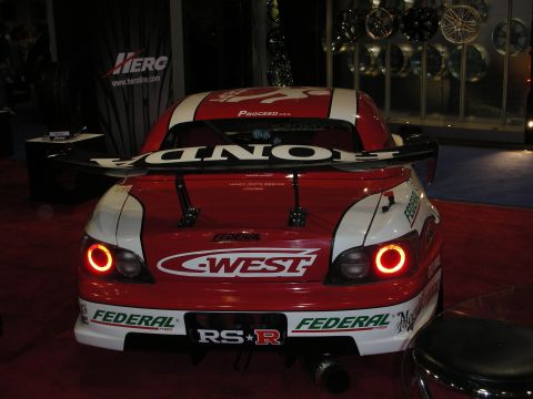 1998 Ford Crown Victoria - Rear view of a red-and-white Honda race car wearing a C-West wing, Federal and RS-R decals with illuminated round taillights.